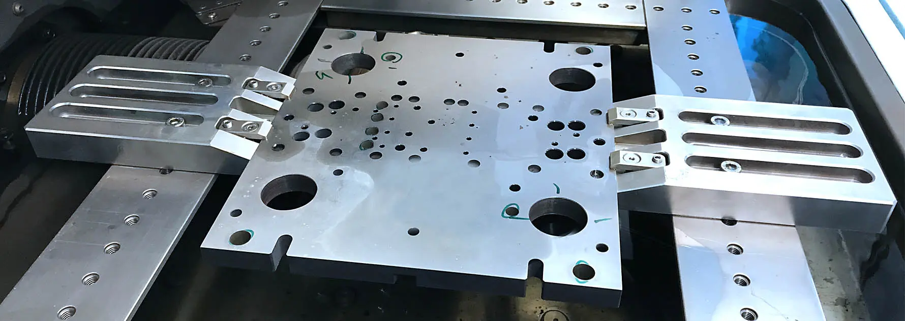 Aufgespannte Lochplatte im Arbeitsraum einer Drahterodiermaschine bei CSM