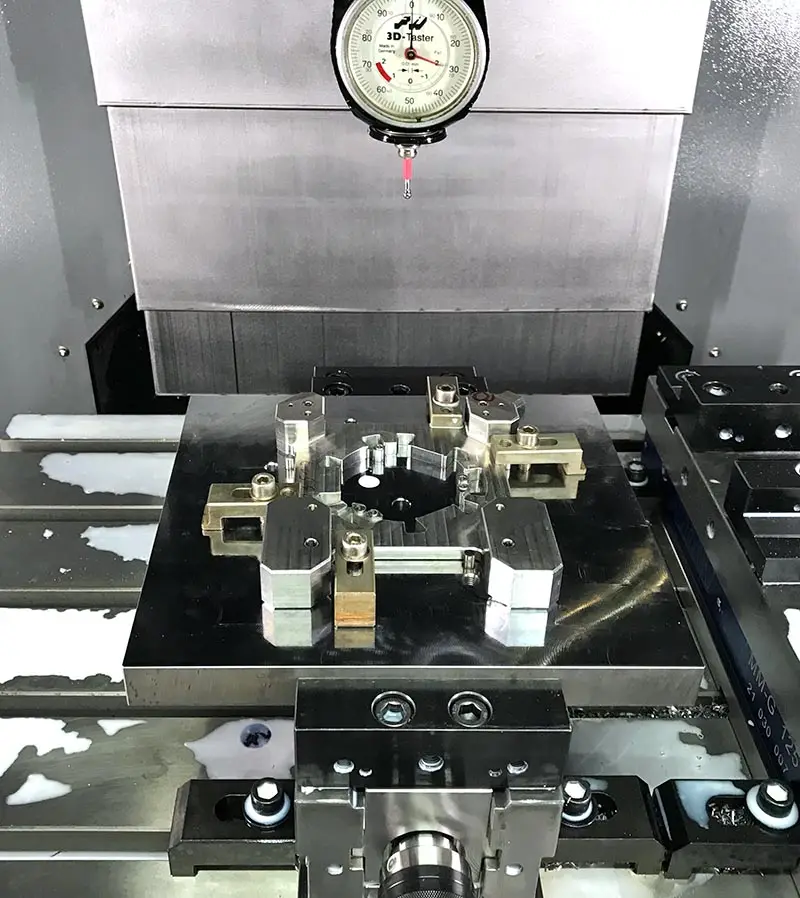 Spannvorrichtung mit Werkstück auf dem Maschinentisch, darüber ein 3D-Taster