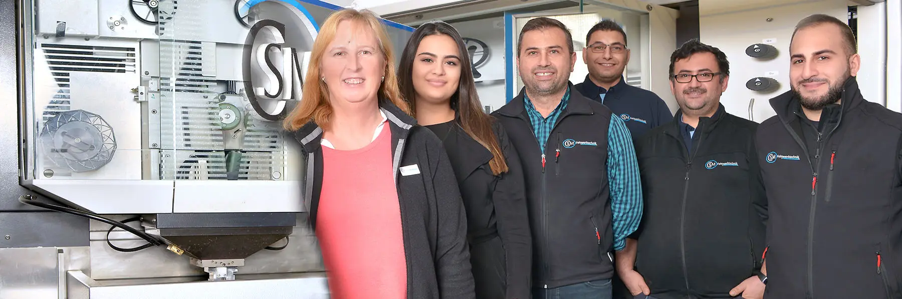 Das Team der CSM Feinwerktechnik GmbH 2025 vor einer Maschine mit CSM-Logo